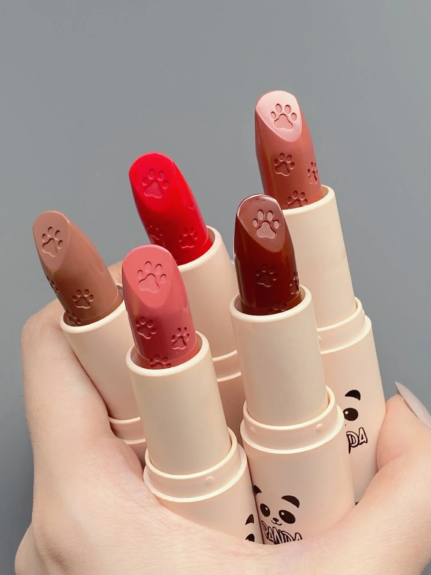 Little white tube matte velvet lipstick with five colour swatches Almond Cinnamon, Amber orange brown, Dirty Orange, Jujube Red Brown, White Peach Bean Paste