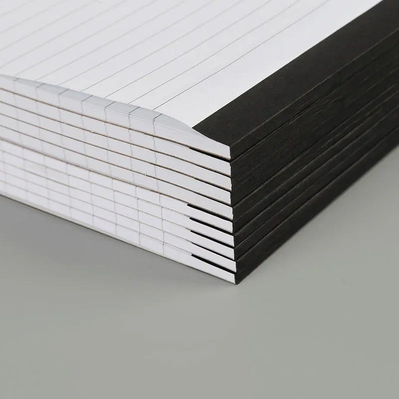 A4 tearable notebook with grid-lined ivory paper and a paper cover, showing wireless adhesive binding