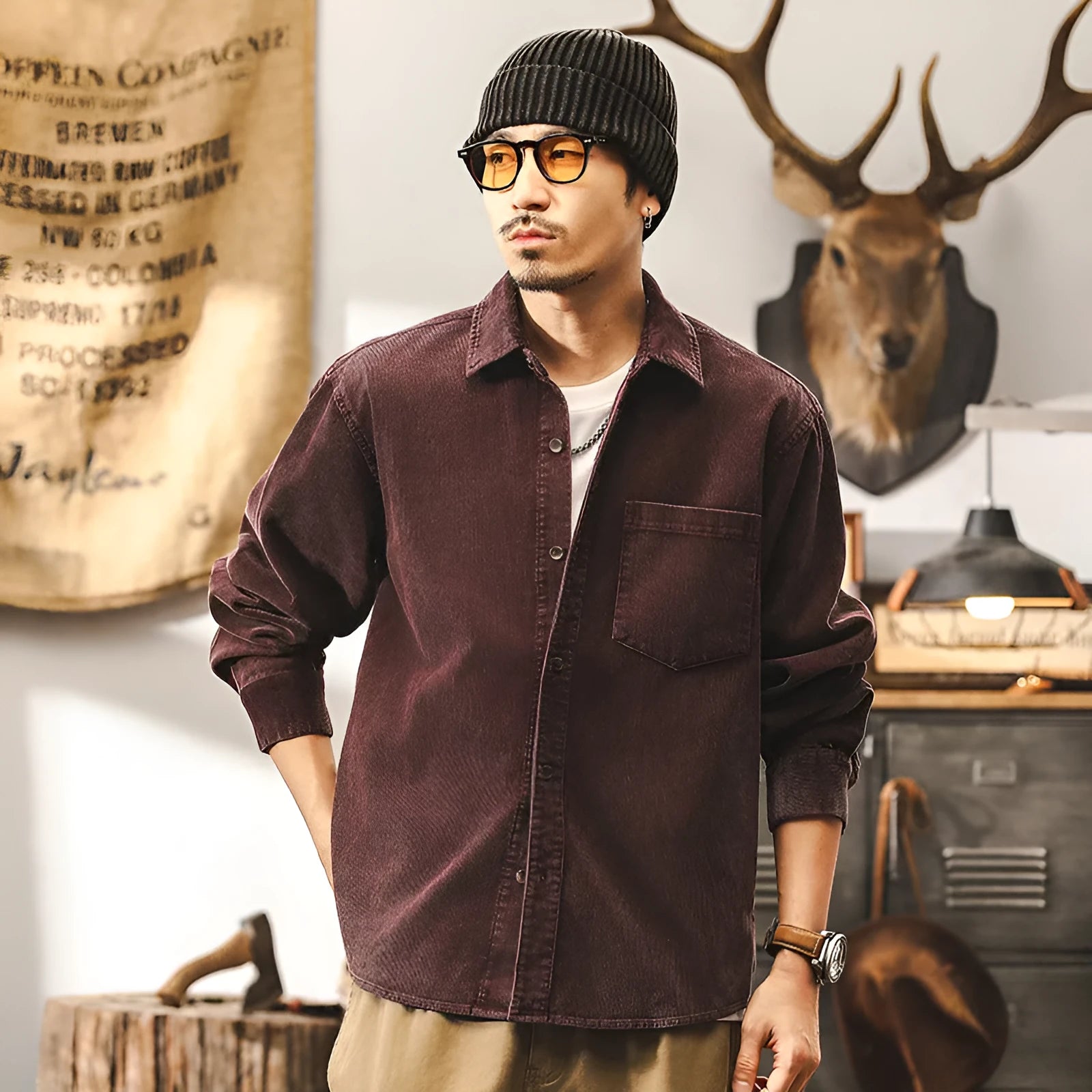 Man wearing a red loose-fit corduroy shirt jacket, showing textured fabric and button-front design.