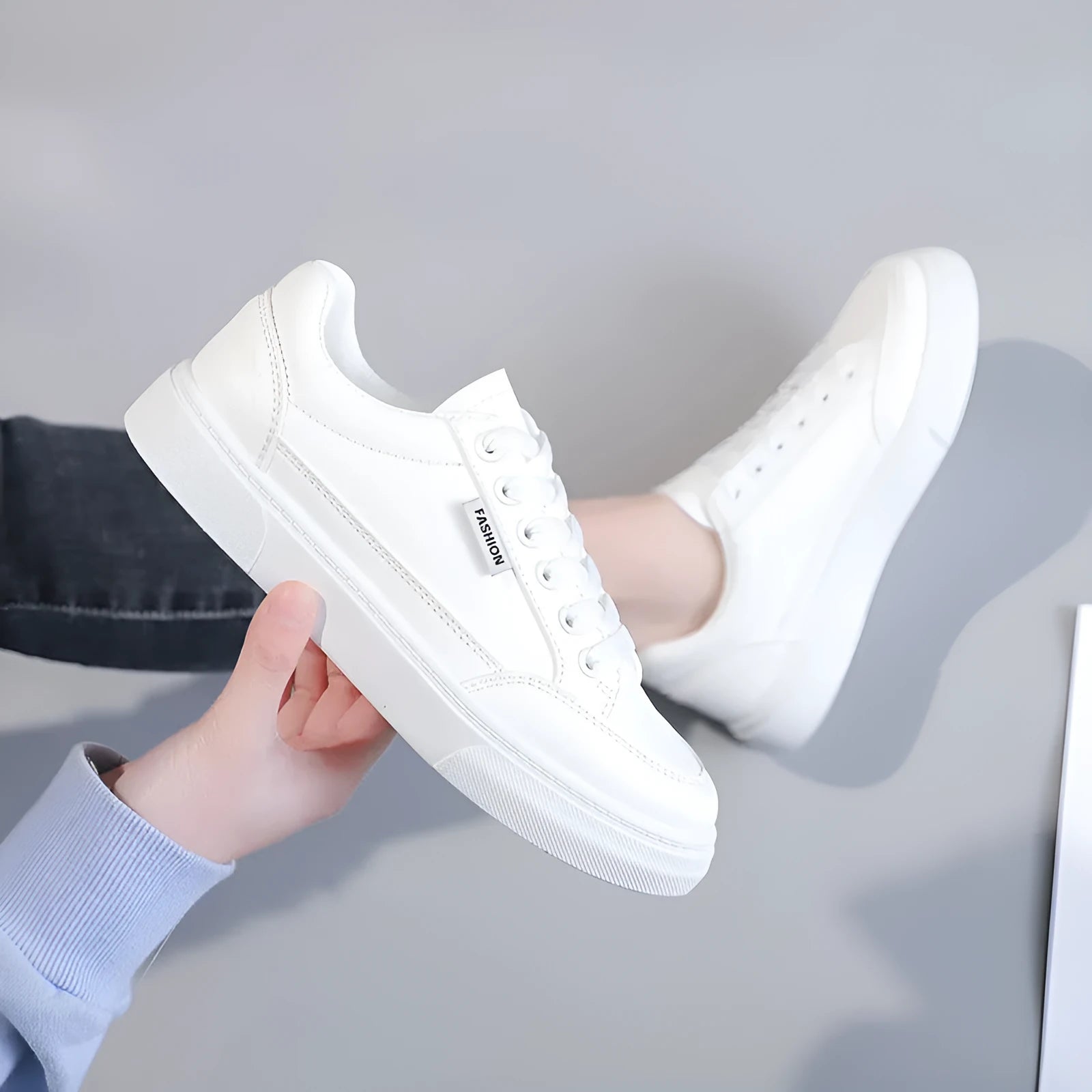 Korean style white low-top women's sneakers with a PU upper on a plain background.