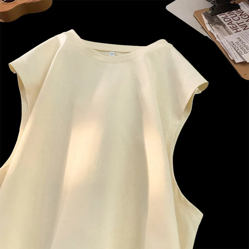 Men's loose-fitting solid colour cotton tank top on a hanger, shown in a light colour.