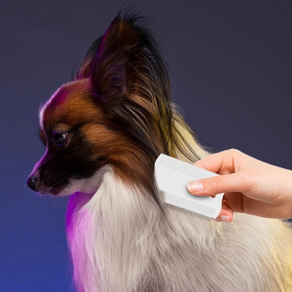 A small white plastic double-sided flea comb for pets, showing both the fine tooth side and the grate mouth side.